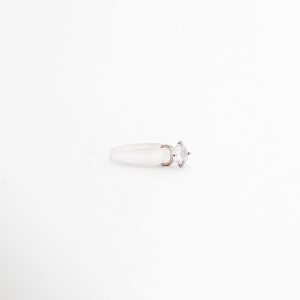 Perfil del Anillo Aeli en plata ley 925 con ágata blanca y zirconia, Vista lateral de anillo minimalista con acabado pulido brillante, Detalle de la montura del Anillo Aeli con piedra central blanca, Anillo de plata con diseño delicado visto de perfil, Vista lateral de anillo elegante con ágata blanca y zirconia.