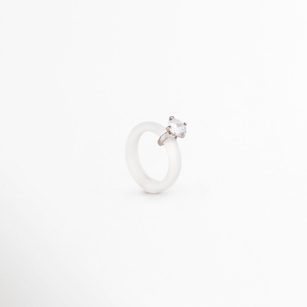 Anillo Aeli desde ángulo lateral mostrando su diseño minimalista, Detalle del anillo de plata 925 con ágata blanca y zirconia brillante, Vista angular de anillo femenino elegante y sofisticado, Anillo refinado con piedra blanca y acabado pulido de alta calidad, Diseño contemporáneo del Anillo Aeli en plata ley 925.