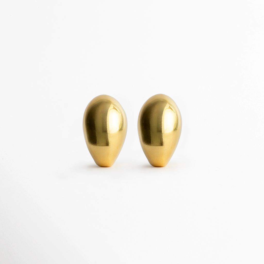 Aretes Golden Nevara abombados en forma de gota esculpida con baño de oro brillante, vista frontal de par sobre fondo blanco, Vista de frente de aretes dorados de volumen redondeado tipo lágrima de 2.7 x 1.8 cm, Par de aretes chunky dorados con silueta orgánica y superficie pulida de alto brillo, Aretes dorados en forma de gota de lluvia estilo gota botánica de inspiración chic francesa.