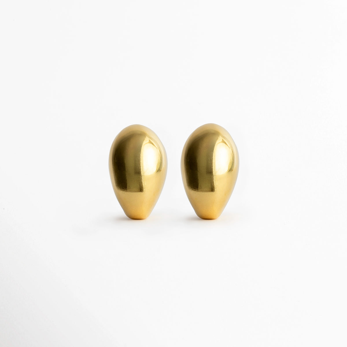 Aretes Golden Nevara abombados en forma de gota esculpida con baño de oro brillante, vista frontal de par sobre fondo blanco, Vista de frente de aretes dorados de volumen redondeado tipo lágrima de 2.7 x 1.8 cm, Par de aretes chunky dorados con silueta orgánica y superficie pulida de alto brillo, Aretes dorados en forma de gota de lluvia estilo gota botánica de inspiración chic francesa.