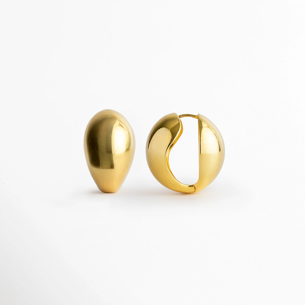 Arete Golden Nevara de perfil con la bisagra ligeramente abierta mostrando el poste integrado, Vista lateral del sistema de cierre snap/huggie de la arracada abombada en forma de gota,  Acercamiento al mecanismo de apertura en bisagra de los aretes dorados de volumen francés, Detalle del poste curvo y el encaje de seguridad de la arracada en forma de gota enchapada en oro.