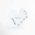 Set Aroa Silver de 3 pares de aretes broquel de circonias transparentes de cortes escalonados (0.4 cm, 0.5 cm y 0.6 cm) enchapados en oro blanco 14K sobre tarjeta de exhibición en forma de corazón, Vista de frente de tres pares de aretes de punto de luz en tono plateado organizados en tarjeta blanca con forma de corazón de la marca Amalaya, Set trío de broqueles básicos de circonia brillante con bisel enchapado en oro blanco de 14 kilates para estilo ear stack.