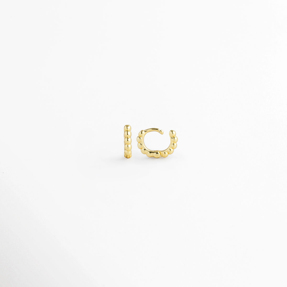 Vista lateral de la Arracada Golden de 8 mm con la bisagra completamente abierta mostrando el poste delgado, Acercamiento al broche articulado abierto de la mini arracada dorada con textura de bolitas de 0.8 cm,  Detalle del sistema de apertura fácil del micro aro huggie de 8 mm sobre fondo claro, Muestra de la precisión de la bisagra en la arracada pequeña de cuentas doradas de 8 mm.