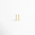 Arracadas Golden Hoops de diseño perlado o de esferas continuas en tono dorado brillante, vista frontal de par sobre fondo blanco, Vista de frente de pequeñas arracadas doradas con textura de cuentas esférias alineadas en relieve, Par de aros tipo huggie dorados con textura punteada / perlada y acabado pulido espejo, Arracadas doradas textura de bolitas de estilo minimalista en electrochapado de alta durabilidad.