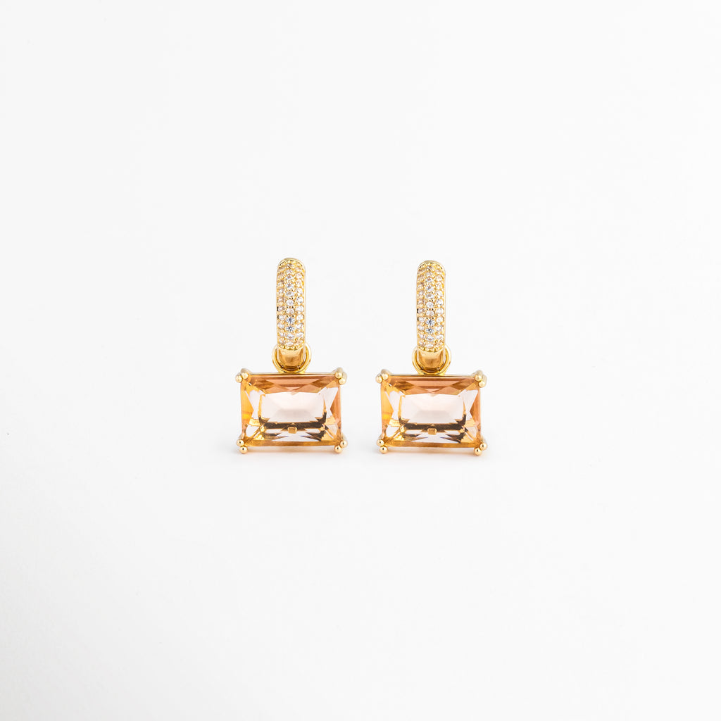 Aretes Soju dorados con argolla de cristales y colgante rectangular color champaña, Pendientes de chapa de oro de 18K con piedra rectangular transparente y circonitas, Par de aretes elegantes con colgante de cristal rectangular sobre fondo blanco, Vista frontal de los aretes Soju chapados en oro con piedras brillantes, Joyería fina para mujer: aretes de argolla con gema rectangular color miel.