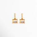 Aretes Soju dorados con argolla de cristales y colgante rectangular color champaña, Pendientes de chapa de oro de 18K con piedra rectangular transparente y circonitas, Par de aretes elegantes con colgante de cristal rectangular sobre fondo blanco, Vista frontal de los aretes Soju chapados en oro con piedras brillantes, Joyería fina para mujer: aretes de argolla con gema rectangular color miel.