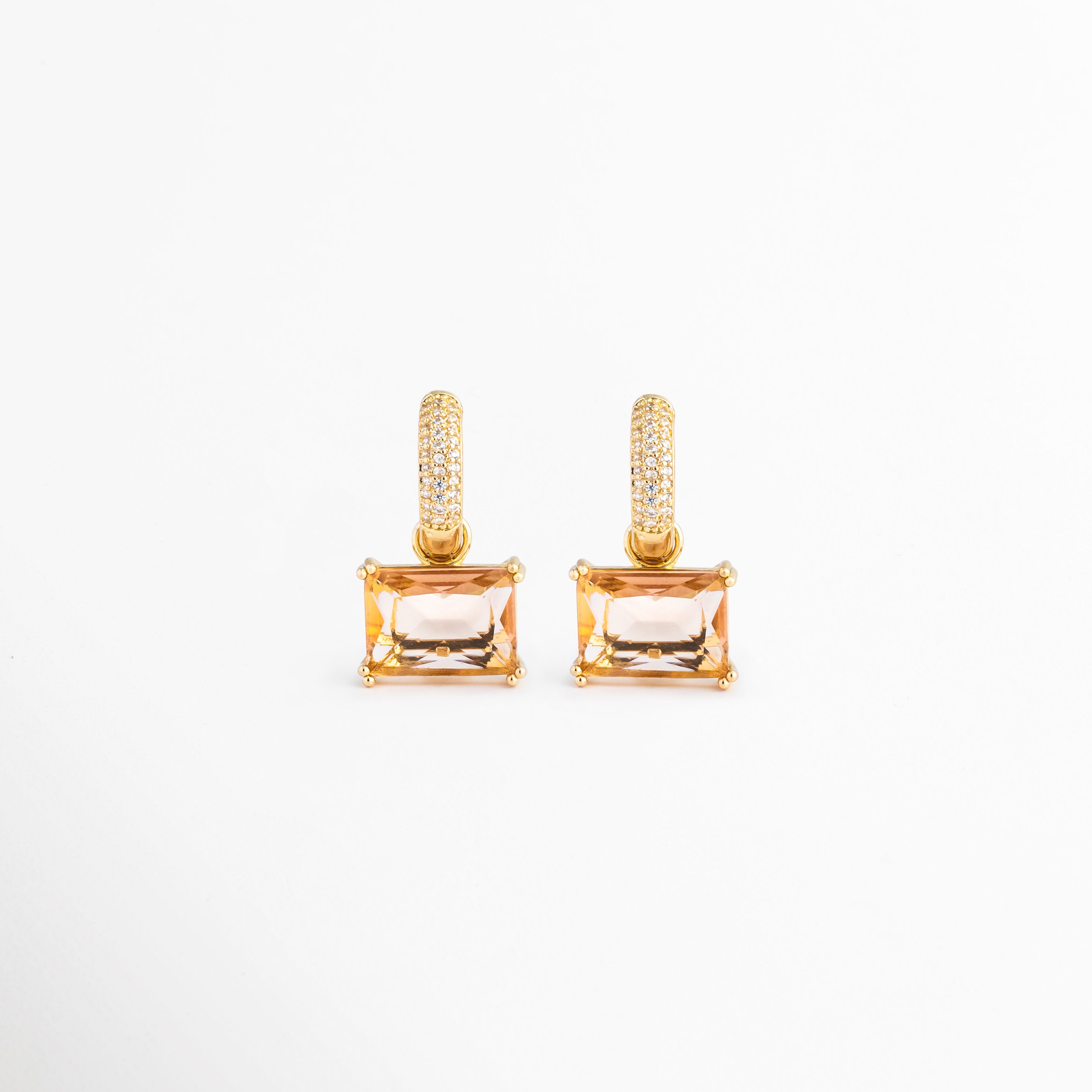 Aretes Soju dorados con argolla de cristales y colgante rectangular color champaña, Pendientes de chapa de oro de 18K con piedra rectangular transparente y circonitas, Par de aretes elegantes con colgante de cristal rectangular sobre fondo blanco, Vista frontal de los aretes Soju chapados en oro con piedras brillantes, Joyería fina para mujer: aretes de argolla con gema rectangular color miel.
