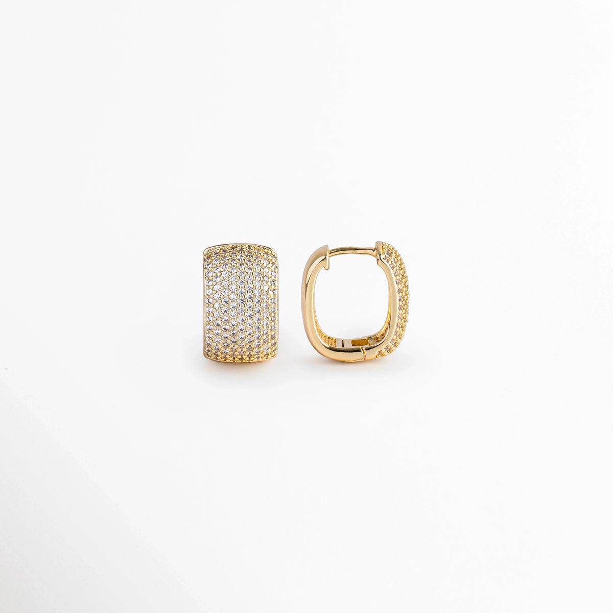 Vista de perfil de uno de los Aretes Bori Golden mostrando el mecanismo de bisagra central y el poste de cierre clic, Acercamiento al sistema de sujeción abraza-lóbulo de la arrancada ancha enchapada en oro 18K, Toma lateral que muestra el reverso metálico pulido y la articulación del broche de seguridad tipo huggie, Muestra del perfil redondeado de 1.8 cm de alto con reverso dorado e incrustación frontal de piedras.  