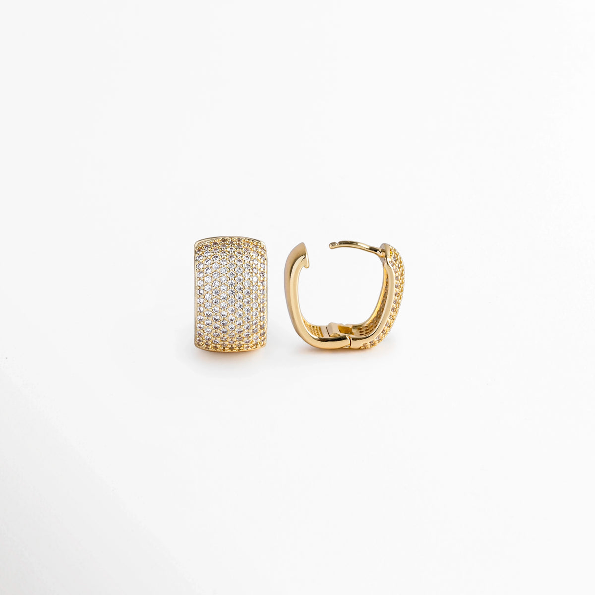 Acercamiento al arete Bori Golden con la bisagra ligeramente abierta mostrando el poste para oreja perforada y la curvatura interna, Vista macro del mecanismo de broche Huggie integrado en la estructura de cobre recubierta en rodio y oro 18K,  Detalle de la construcción sólida y ergonómica de la arrancada ancha con piedras preciosas artificiales, Muestra de la fácil apertura y seguridad del cierre abraza-lóbulo en tono oro brillante. 