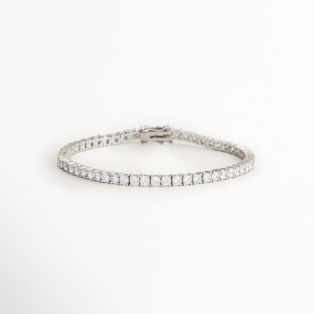 Vista en ángulo de la Pulsera Tennis Silver Francheskaar mostrando la hilera de zirconias y el acabado en Oro Blanco 14K, Perspectiva de la Pulsera Tennis Silver Francheskaar resaltando el brillo de las zirconias, Pulsera Tennis Silver Francheskaar fotografiada en ángulo mostrando su diseño tipo tennis, Vista diagonal de la Pulsera Tennis Silver Francheskaar con zirconias y acabado plateado, Pulsera Tennis Silver Francheskaar en perspectiva destacando su diseño fino y elegante.