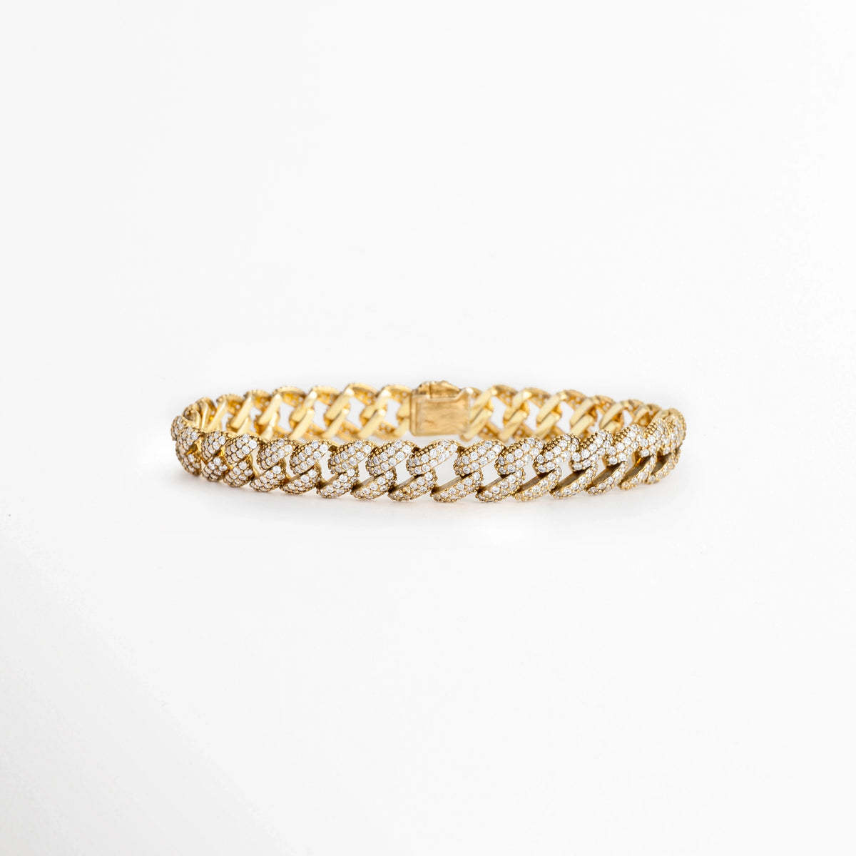 Pulsera Golden Margot de plata ley 925 enchapada en oro 18K de 16 cm con eslabones cubanos de 0.9 cm cuajados en diamantes sintéticos, vista frontal sobre fondo blanco, Vista de frente de pulsera de eslabones barbados estilo cubana dorada con pavé continuo de diamantes sintéticos brillantes, Plano general de pulsera estilo barbada cubana en plata ley 925 con recubrimiento enchapado en oro 18K sobre fondo neutro, Pulsera Golden Margot destacando la simetría 