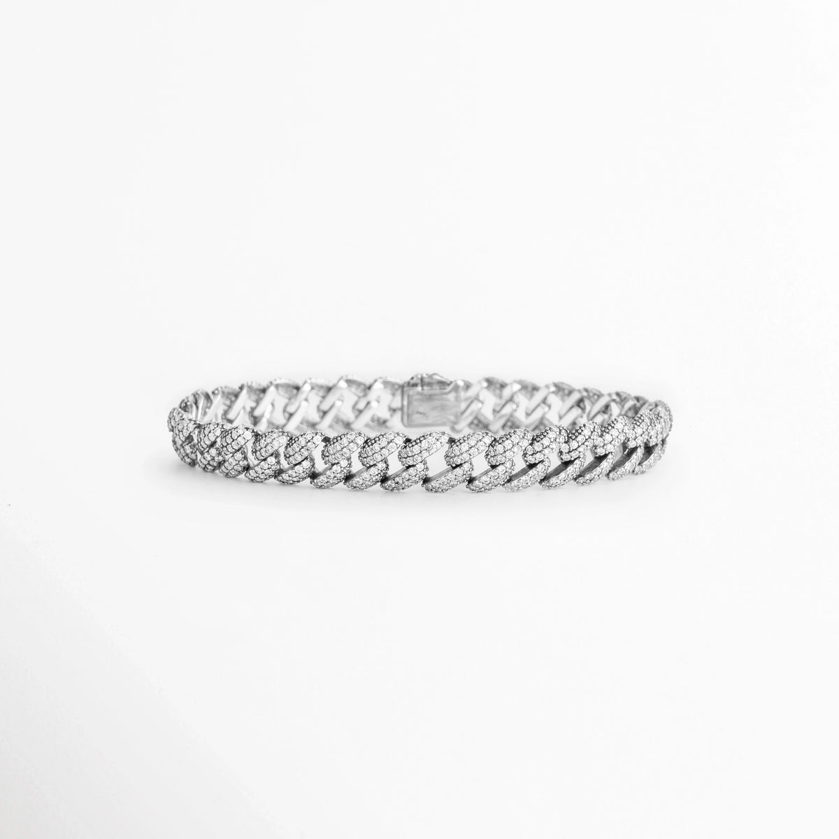 Pulsera Silver Margot de plata ley 925 enchapada en oro blanco 18K de 20 cm con eslabones cubanos de 0.9 cm cuajados en diamantes sintéticos, vista frontal sobre fondo blanco, Vista de frente de pulsera de eslabones barbados estilo cubana plateada con pavé continuo de diamantes sintéticos brillantes, Plano general de pulsera estilo barbada cubana en plata ley 925 con recubrimiento de oro blanco 18K sobre fondo neutro, Pulsera Silver Margot destacando la simetría