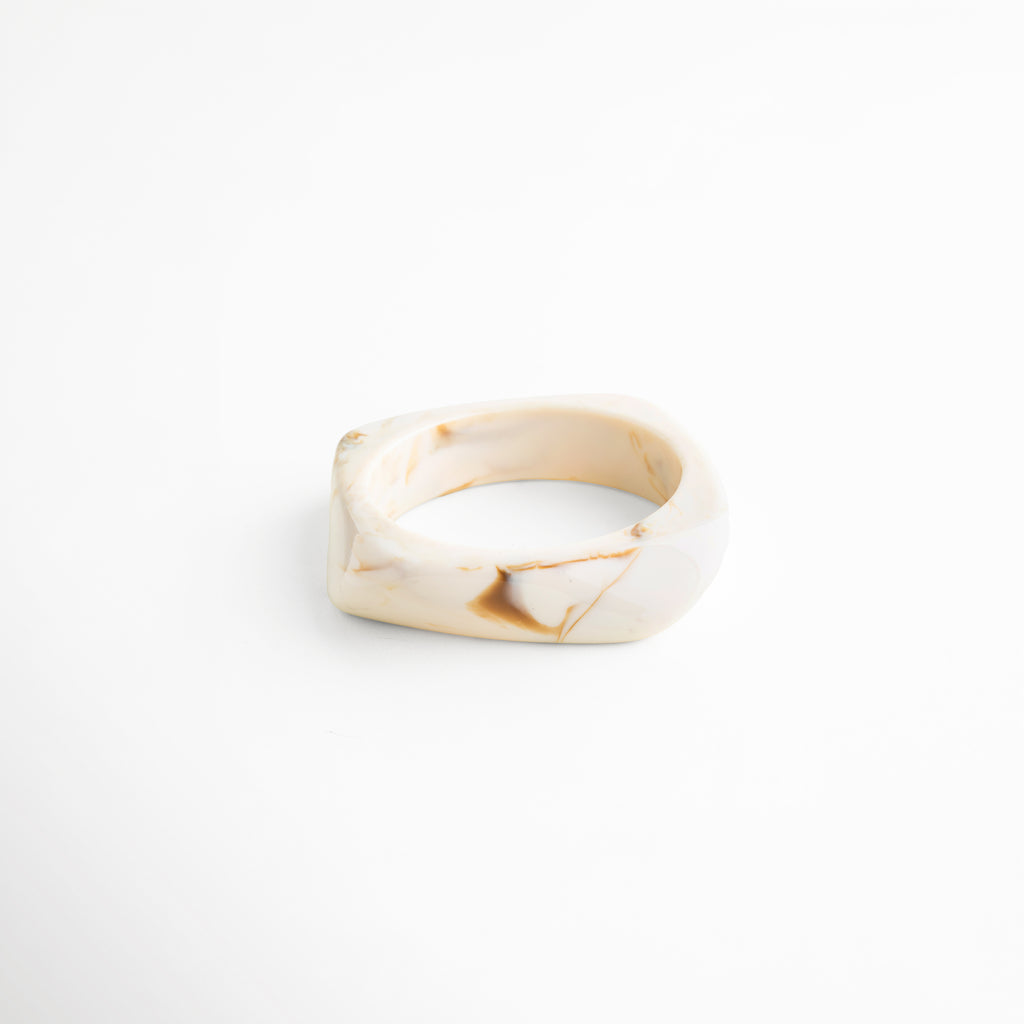 Pulsera de resina beige diseño ancho vista frontal elegante, Pulsera cuff resina acabado brillante estilo minimalista moderno, Pulsera orgánica de resina tono marfil diseño limpio frontal, Pulsera statement resina forma irregular elegante vista frontal, Pulsera ancha moderna de resina color neutro uso diario