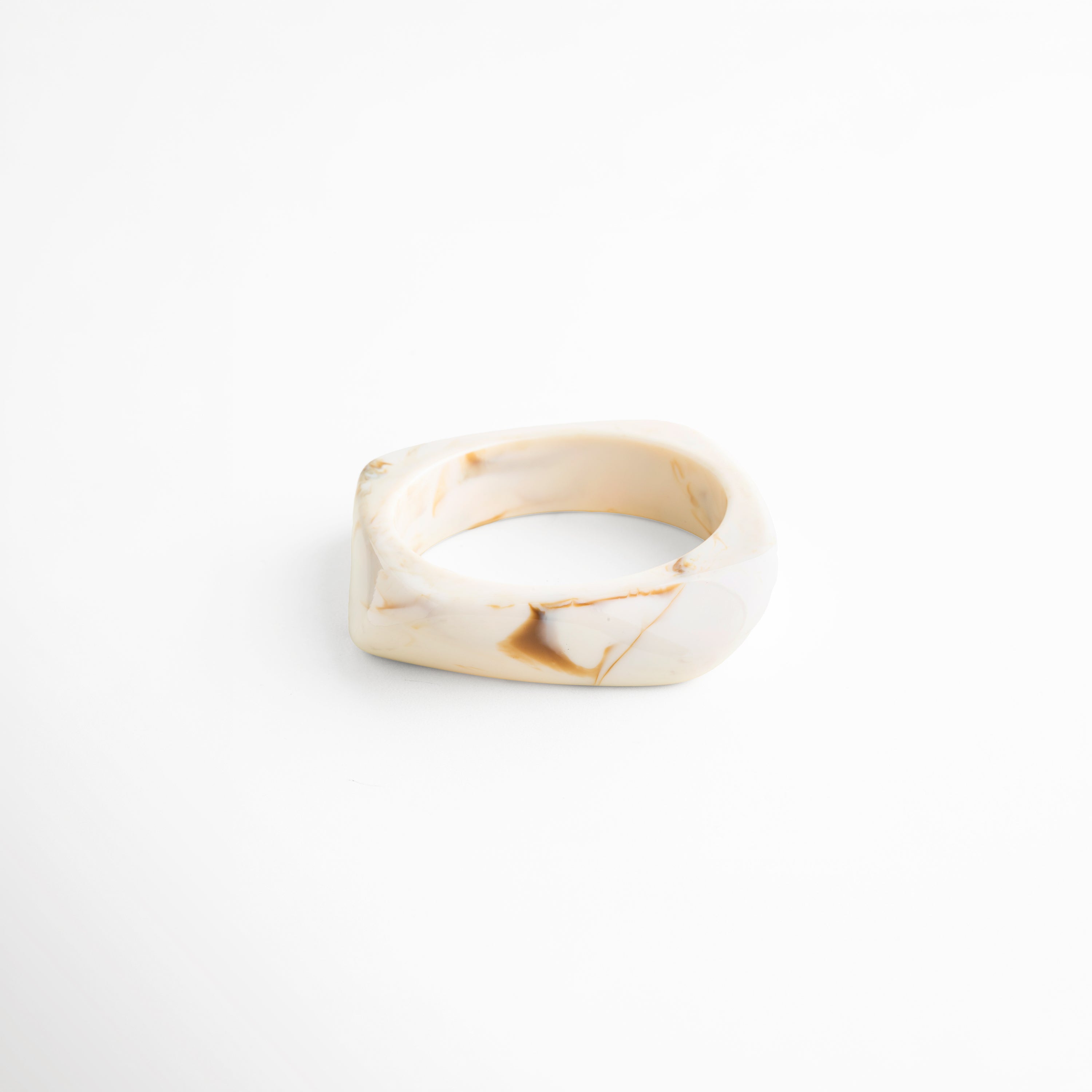 Pulsera de resina beige diseño ancho vista frontal elegante, Pulsera cuff resina acabado brillante estilo minimalista moderno, Pulsera orgánica de resina tono marfil diseño limpio frontal, Pulsera statement resina forma irregular elegante vista frontal, Pulsera ancha moderna de resina color neutro uso diario