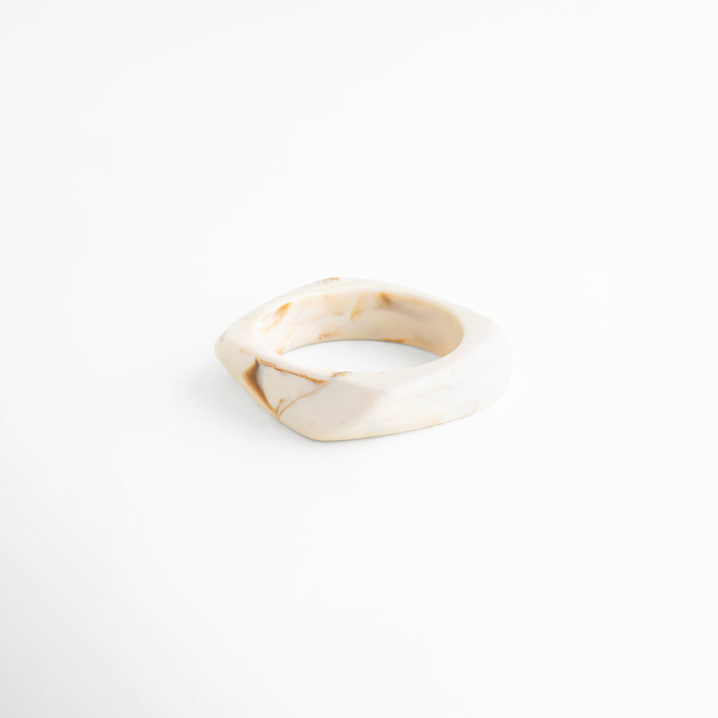 Pulsera de resina beige ángulo diagonal acabado brillante elegante, 
Pulsera cuff resina diseño orgánico detalle forma irregular, Pulsera moderna de resina tono neutro estilo sofisticado, 
Pulsera ancha resina acabado pulido detalle contemporáneo, Pulsera statement resina beige diseño fluido elegante