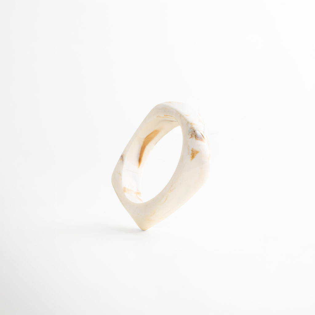 Pulsera de resina beige abierta diseño orgánico acabado brillante, Pulsera cuff de resina tono marfil forma irregular moderna, Pulsera ancha de resina acabado pulido estilo contemporáneo, Pulsera statement de resina diseño fluido elegante, Pulsera moderna de resina beige estructura abierta sofisticada