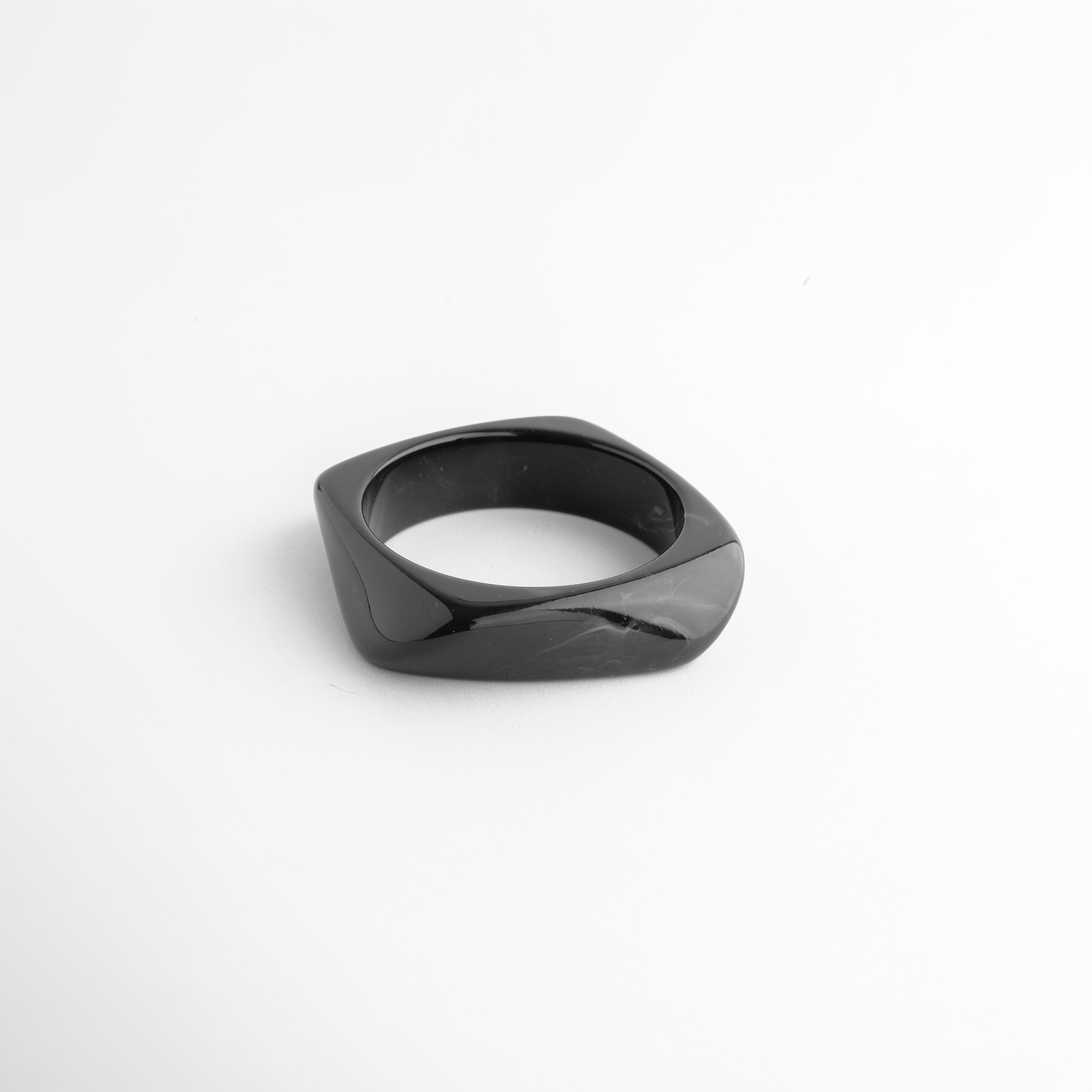 Pulsera negra de resina ángulo diagonal acabado brillante elegante, Pulsera cuff resina negra diseño orgánico detalle sofisticado, Pulsera moderna negra estilo contemporáneo minimalista, Pulsera ancha resina negra acabado pulido detalle diseño, Pulsera statement negra de resina forma fluida elegante