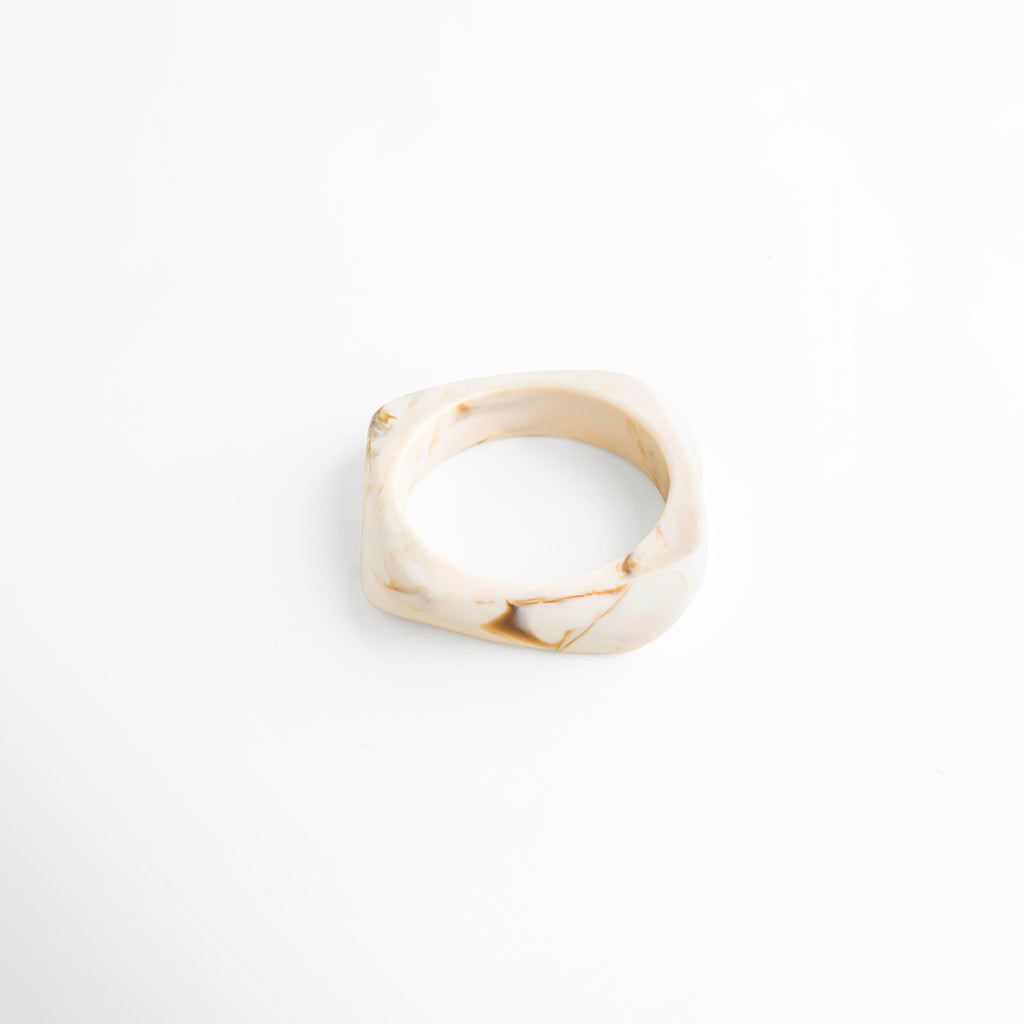 Pulsera de resina beige vista superior diseño abierto moderno, Pulsera cuff resina tono marfil acabado brillante vista superior, Pulsera ancha resina forma irregular diseño contemporáneo, Pulsera minimalista de resina vista superior estilo elegante, Pulsera moderna de resina diseño fluido acabado pulido