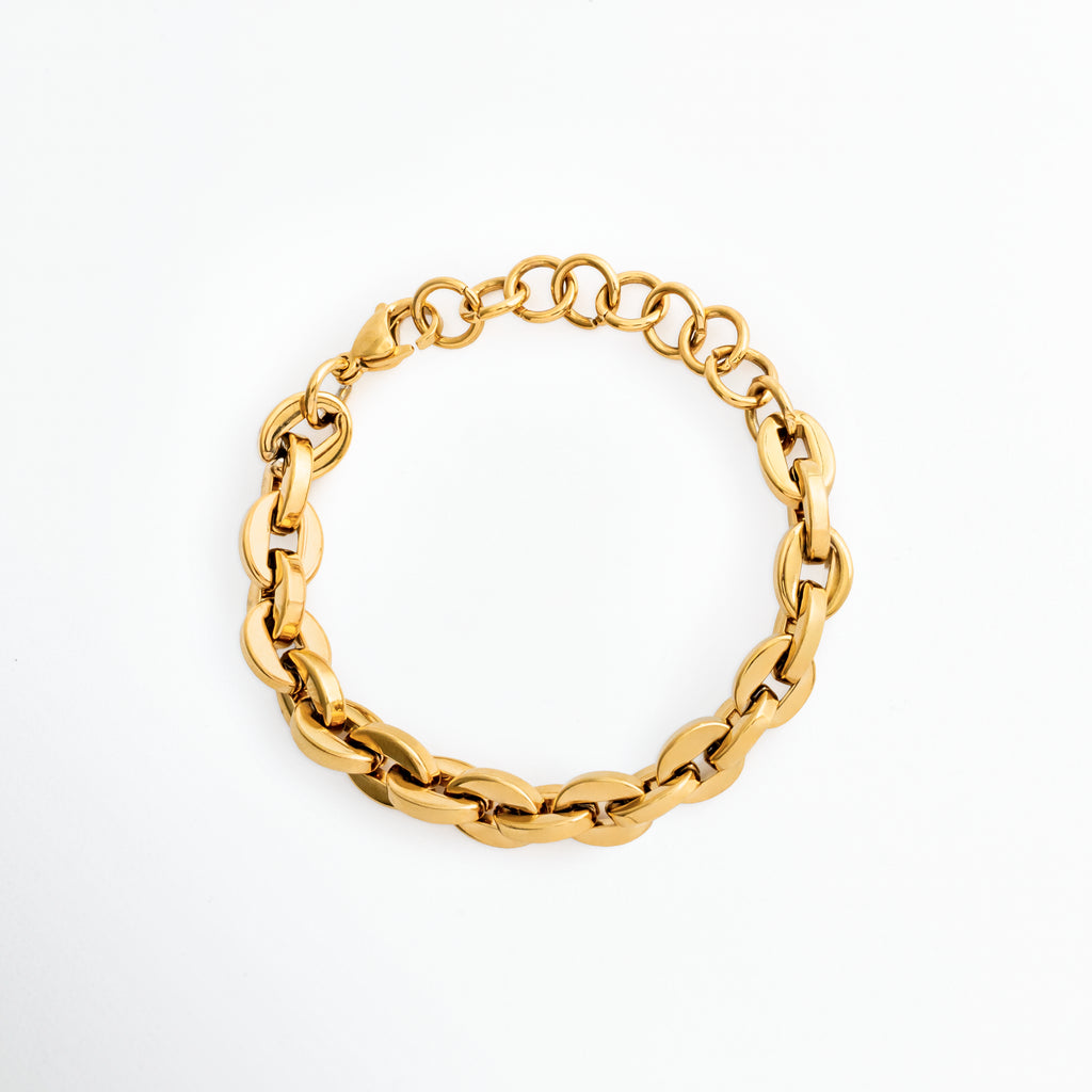 Pulsera Empress dorada enchapada en oro 18K de acero inoxidable con eslabones entrelazados de estilo grano de café y extensión de argollas, vista superior sobre fondo blanco, Vista de frente de pulsera robusta de cadena gruesa entrelazada con broche de langosta y eslabones ajustables, Plano general de brazalete dorado de eslabones ovalados entrelazados de 1.1 cm de ancho en posición circular, Pulsera Empress de acero inoxidable con baño de oro 18K