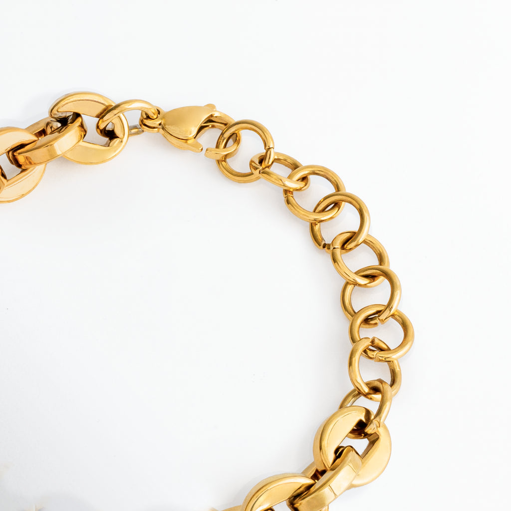 Acercamiento al broche de perico y a la cadena de argollas de extensión ajustable de la Pulsera Empress, Vista macro del sistema de cierre seguro en acero inoxidable enchapado en oro 18K, Detalle de la transición entre los eslabones robustos de 1.1 cm y las argollas delgadas de ajuste, Muestra de la extensión de cadena de ajuste que permite adaptar el largo de la pulsera.