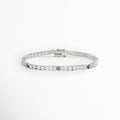 Pulsera tennis enchapada en oro blanco de 17 cm con circonias cristalinas y pequeños detalles de ojo turco azul, vista superior sobre fondo blanco, Vista de frente de pulsera estilo tennis plateada de 0.3 cm de ancho con engaste continuo de pedrería y amuletos de ojo turco, Plano general de pulsera de circonias transparentes con acentos de protección de ojo turco azul en acabado plateado, Pulsera tennis plateada de cobre enchapado en oro blanco con pedrería brillante
