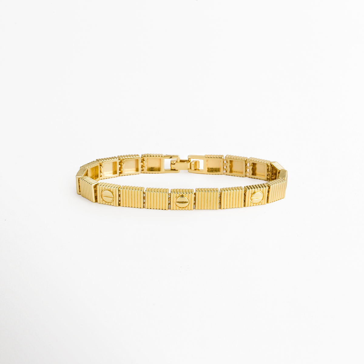 Pulsera Golden Alba enchapada en oro 18K de acero inoxidable con eslabones rectangulares de textura acanalada y motivo de tornillo, vista superior sobre fondo blanco, Vista de frente de brazalete dorado de 0.6 cm de ancho con placas articuladas geométricas y relieve de líneas verticales, Plano general de pulsera dorada con eslabones cuadrados con textura de estrías y detalles de tornillo pulido, Pulsera Golden Alba de acero inoxidable enchapada en oro 18K