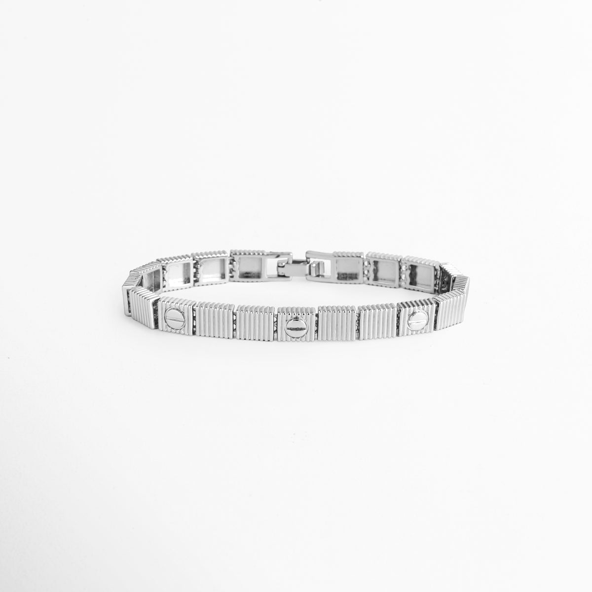 Pulsera Silver Alba enchapada en oro blanco 18K de acero inoxidable con eslabones rectangulares de textura acanalada y motivo de tornillo, vista superior sobre fondo blanco, Vista de frente de brazalete plateado de 0.6 cm de ancho con placas articuladas geométricas y relieve de líneas verticales, Plano general de pulsera plateada con eslabones cuadrados con textura de estrías y detalles de tornillo pulido, Pulsera Silver Alba de acero inoxidable enchapada en oro blanco