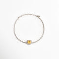 Pulsera Yellow estilo tennis enchapada en oro blanco con circonia central de corte cojín en color amarillo canario enmarcada por un halo brillante, vista superior sobre fondo blanco, Vista de frente de pulsera plateada delgada con gema central de circonia amarilla cuadrada y halo de pedrería transparente, Plano general de pulsera estilo tennis enchapada en oro blanco con gema amarilla en el centro y cadena de extensión, Pulsera Yellow de cobre enchapado en oro