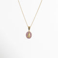 Collar Medallón Dorado Virgen de cobre enchapado en oro con dije ovalado de la Virgen y halo de circonias violeta o lila, vista frontal sobre fondo blanco, Vista de frente de collar dorado con medallón de la Virgen de Guadalupe de 2.5 cm de largo rodeado de circonias violetas brillante, Plano general de collar fino en tono oro con dije religioso ovalado y halo de pedrería lila sobre fondo neutro, Collar Medallón Dorado Virgen destacando el contraste entre la figura 