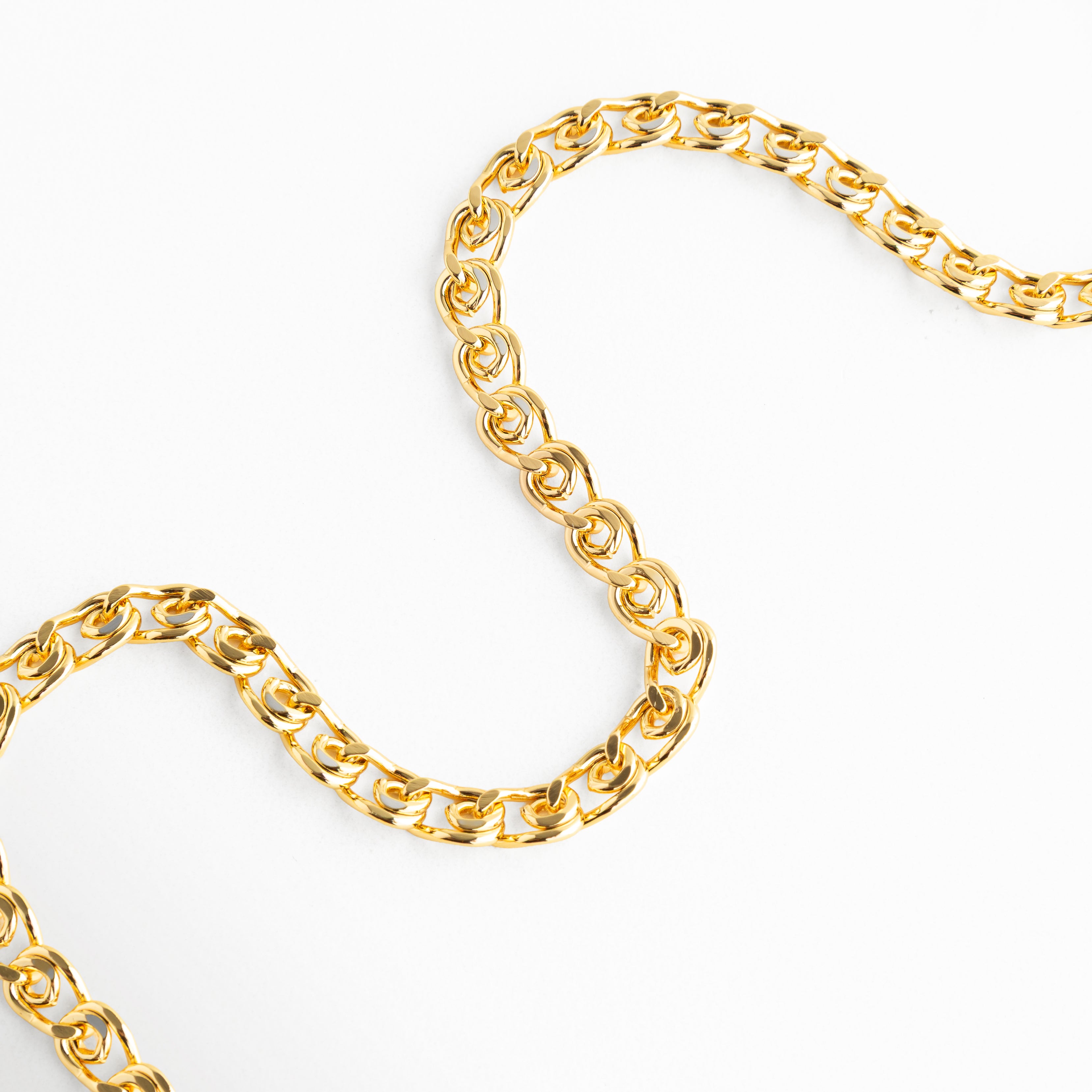 Detalle de Collar Fellini con eslabones dorados brillantes, Collar Fellini con forma curva y diseño de cadena elegante, Close up de Collar Fellini con eslabones modernos dorados, Collar Fellini con acabado en oro 18K y textura brillante, Detalle de cadena Fellini dorada con diseño sofisticado