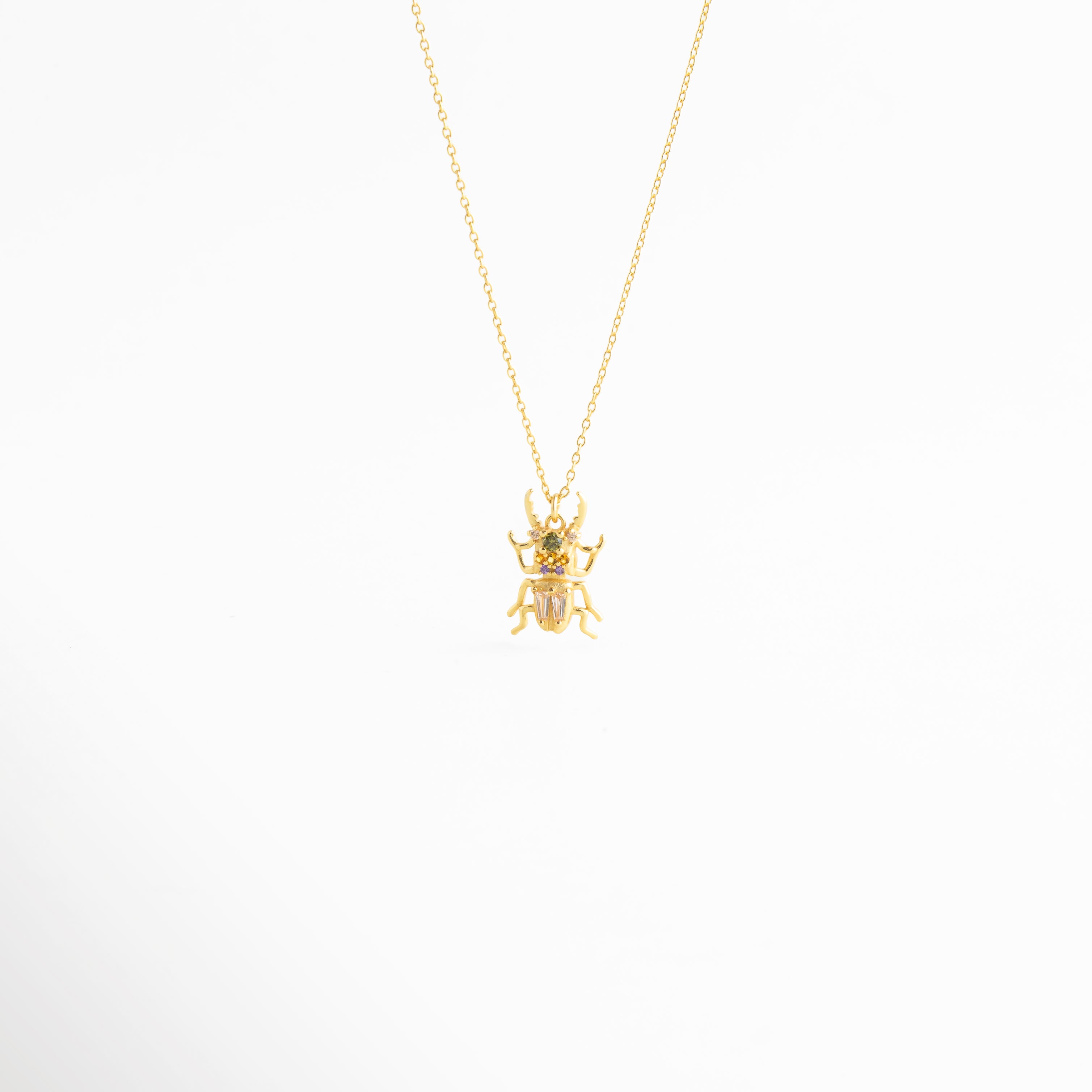 Collar Beetle dorado con dije de escarabajo y zirconias brillantes en diseño elegante, Collar delicado con dije de escarabajo en acabado oro 18K y detalles de zirconia, Cadena fina con colgante de escarabajo inspirado en un diseño místico y sofisticado, Collar de Plata Ley 925 con dije de beetle dorado y brillo sutil, Collar femenino con colgante de escarabajo y acabado refinado en oro y plata.