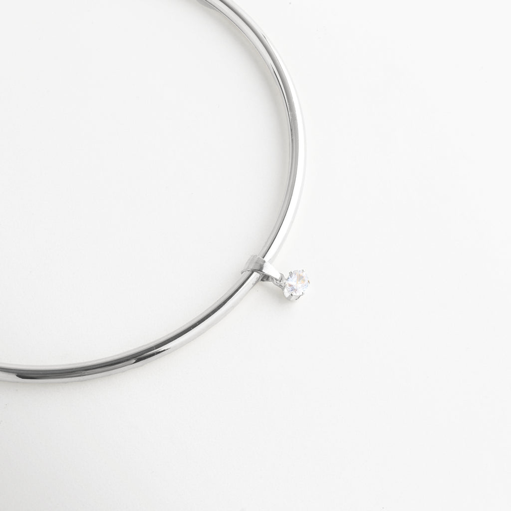 Detalle del Collar Silver Aureva con zirconia central suspendida y brillo elegante, Vista cercana del dije de zirconia en collar plateado de diseño refinado, Detalle del colgante central con zirconia brillante y acabado pulido, Collar plateado con zirconia suspendida en diseño delicado y moderno, Acercamiento del detalle central del Collar Silver Aureva con brillo sutil.