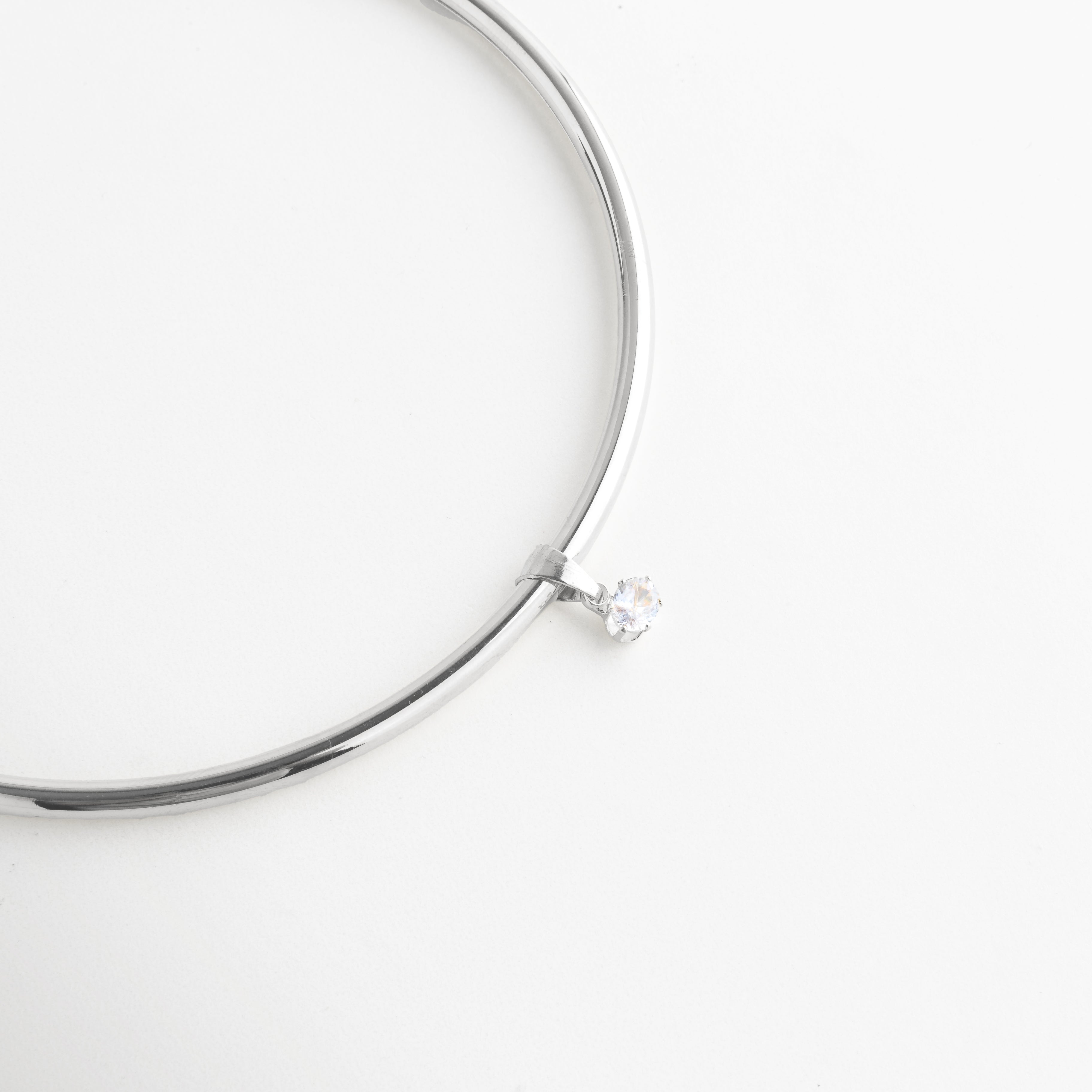 Detalle del Collar Silver Aureva con zirconia central suspendida y brillo elegante, Vista cercana del dije de zirconia en collar plateado de diseño refinado, Detalle del colgante central con zirconia brillante y acabado pulido, Collar plateado con zirconia suspendida en diseño delicado y moderno, Acercamiento del detalle central del Collar Silver Aureva con brillo sutil.