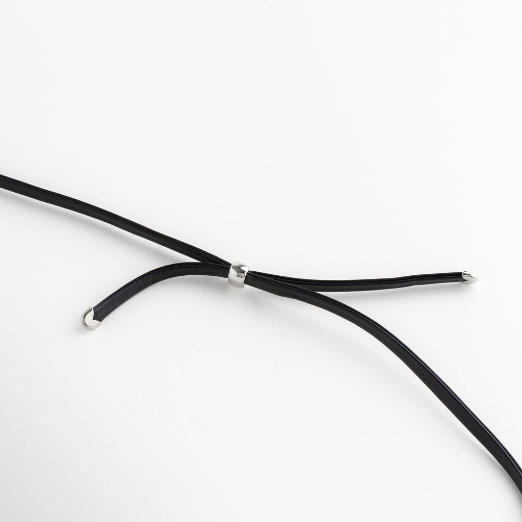 Primer plano del pasador metálico ajustable en el cordón de cuero del collar, Detalle de los terminales de acero enchapado en las puntas del cordón negro, Mecanismo de ajuste del collar Silver Monet con componentes de acero mate, Zoom a los acabados de calidad en el cordón de cuero y herrajes plateados, Vista técnica del cierre y puntas del collar para mostrar la durabilidad del material.