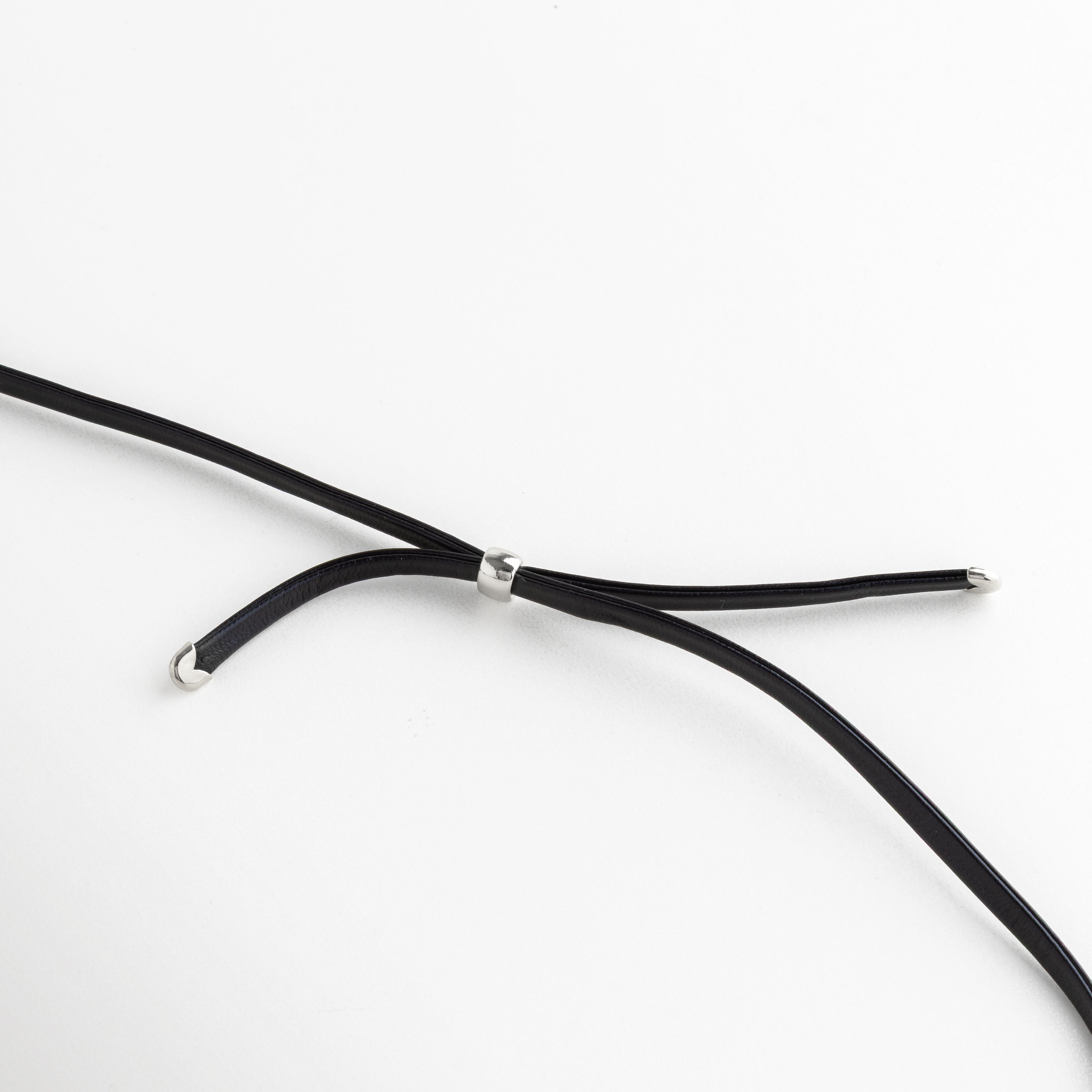 Primer plano del pasador metálico ajustable en el cordón de cuero del collar, Detalle de los terminales de acero enchapado en las puntas del cordón negro, Mecanismo de ajuste del collar Silver Monet con componentes de acero mate, Zoom a los acabados de calidad en el cordón de cuero y herrajes plateados, Vista técnica del cierre y puntas del collar para mostrar la durabilidad del material.