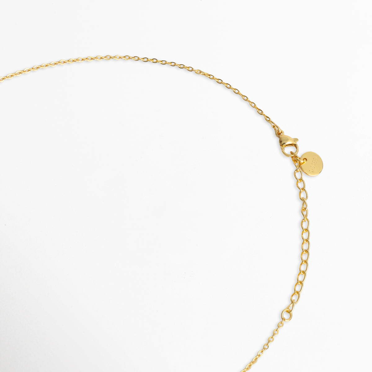Detalle del cierre de broche de reasa/mosquetón con cadena de extensión de 5 cm y chapita distintiva de la marca en tono dorado, Vista de cerca del sistema de ajuste del Collar Prisma Dorado en enchapado de oro, Acercamiento a los eslabones finales y mecanismo de seguridad de la cadena dorada, Detalle de la terminación pulida de la extensión ajustable del collar Prisma Dorado.