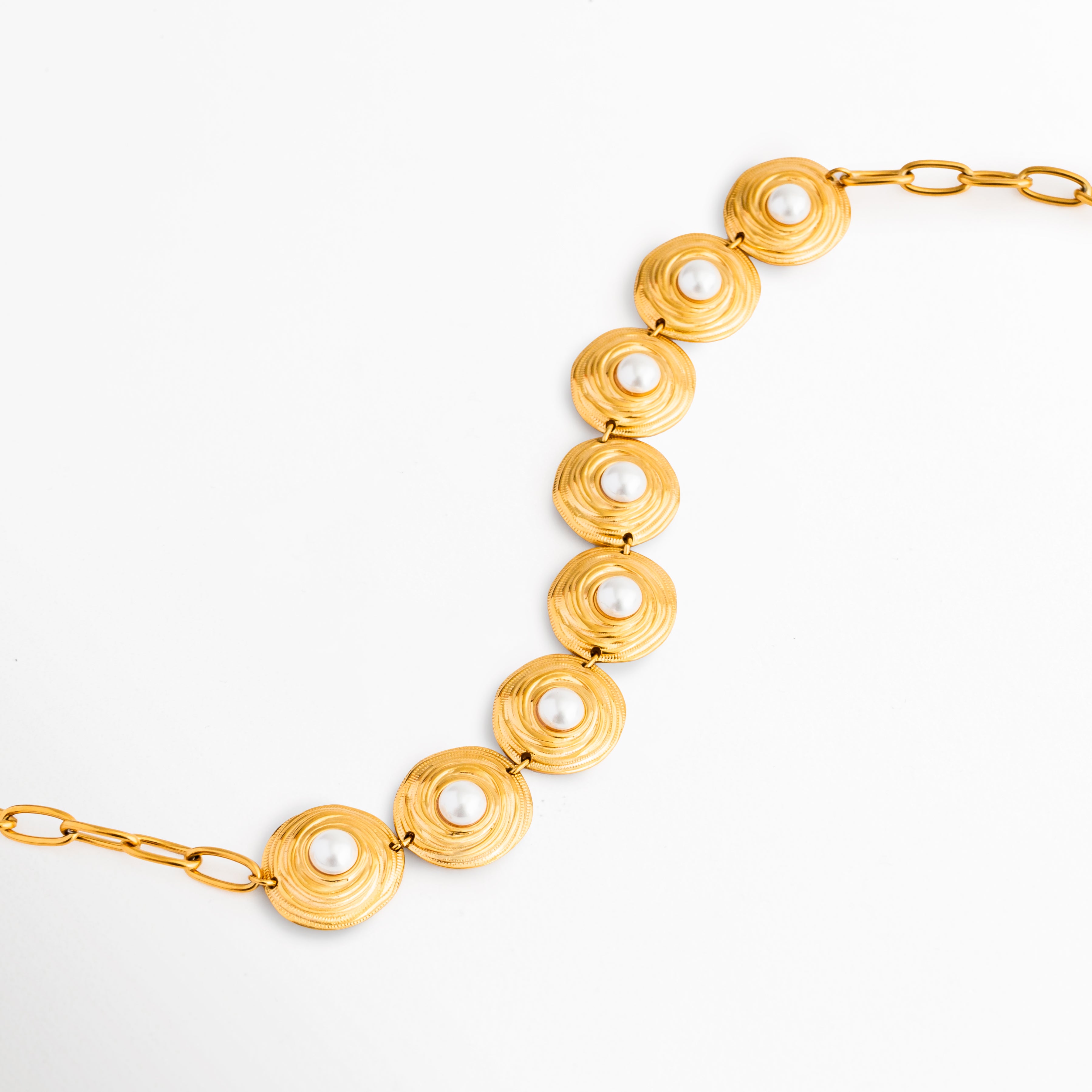 Detalle del Collar Khalira con perlas de alto brillo, Acercamiento a las perlas brillantes y acabado dorado elegante, Collar con incrustaciones de perla y diseño refinado, Detalle de joyería femenina con perlas y baño de Oro 18K, Perlas luminosas que aportan un toque sofisticado al collar.