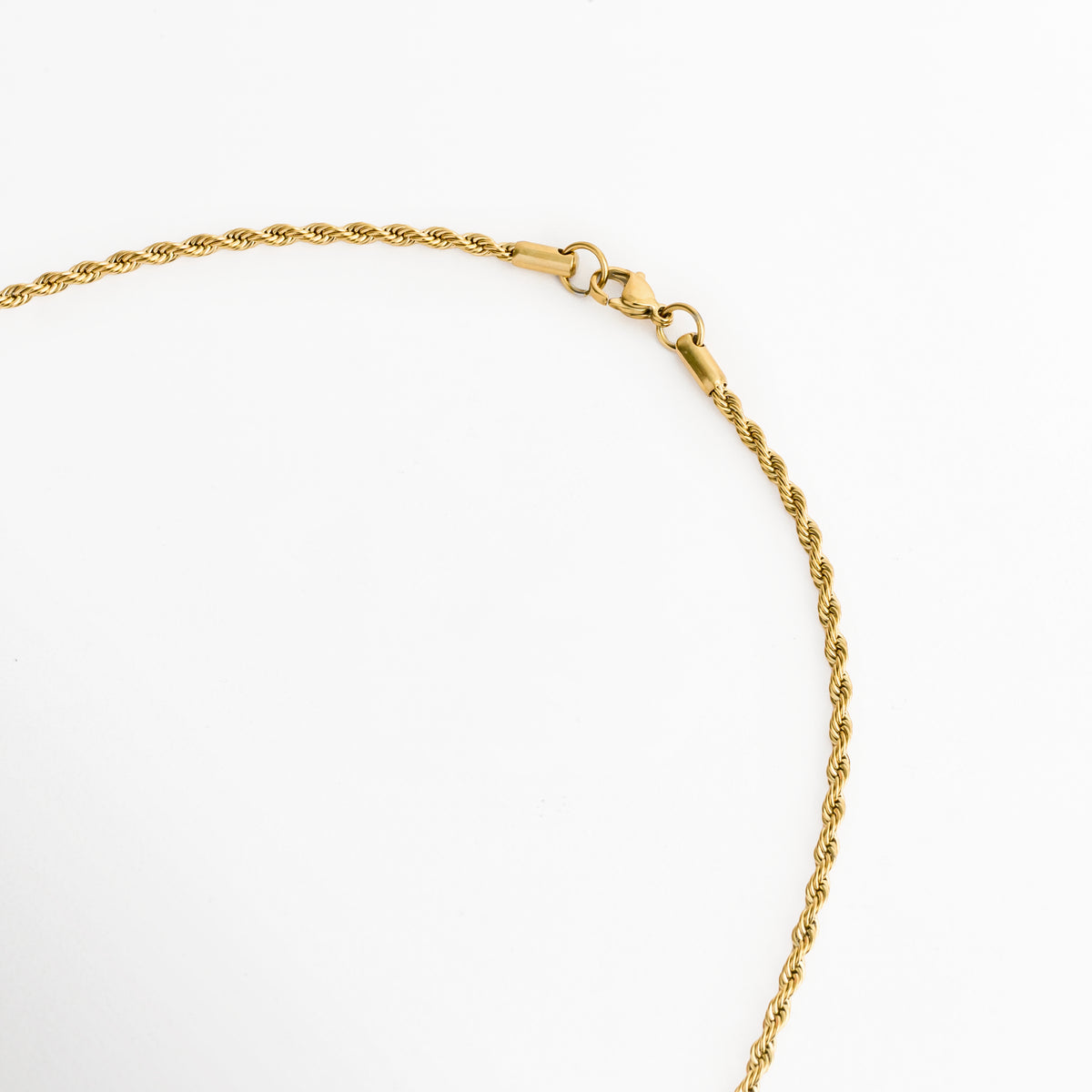 Acercamiento al broche de langosta o reasa en la cadena de cordón de 55 cm del Collar Padre Nuestro Bitono, Vista macro del sistema de cierre seguro en acabado dorado brillante sobre fondo blanco, Detalle del tejido tipo torzal de la cadena y la terminación del cierre enchapado en oro 18K, Muestra del mecanismo de sujeción metálico pulido de la cadena dorada.   
