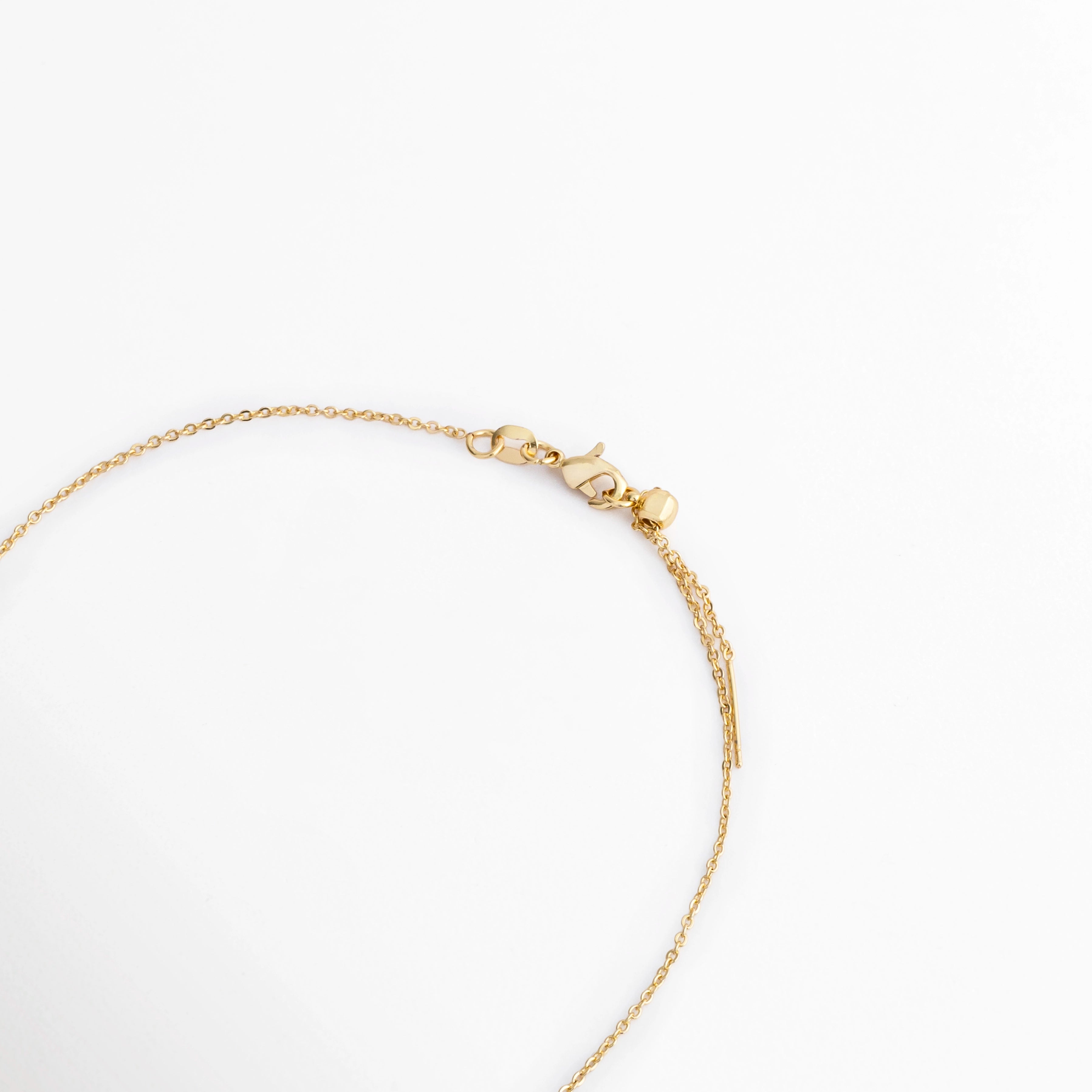 Vista del cierre y cadena del Collar Modi con acabado en oro, Detalle de la cadena fina y broche del Collar Modi elaborado en cobre, Acercamiento del sistema de cierre del Collar Modi con recubrimiento en oro, Vista parcial de la cadena del Collar Modi con acabado dorado y cierre de broche, Detalle del collar Modi que muestra la cadena fina y el cierre metálico.