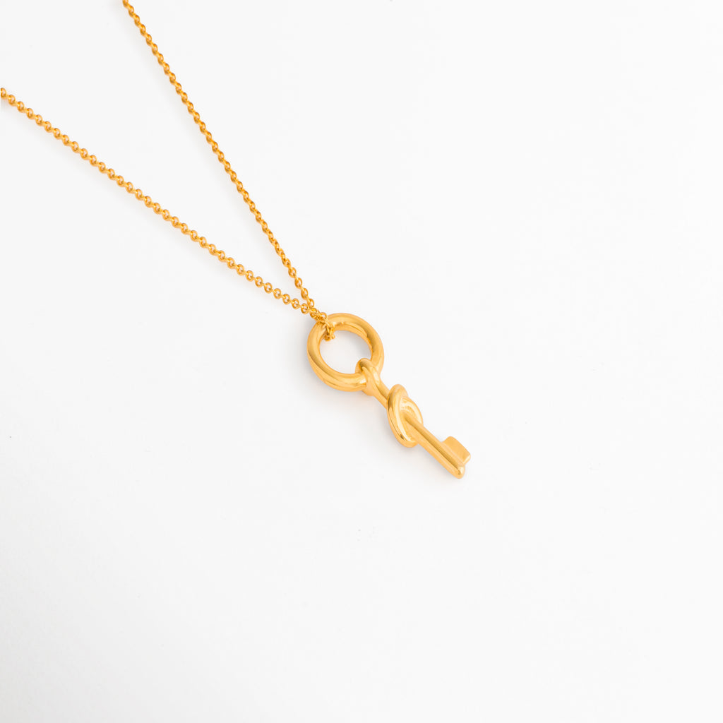 Detalle del Collar Golden Selka con colgante circular y acabado en oro 18K, Vista cercana del dije geométrico dorado con diseño moderno y elegante, Collar con colgante minimalista de líneas limpias y estilo contemporáneo, Detalle de joyería dorada con forma circular y elemento colgante, Acercamiento al dije Golden Selka con brillo sutil y acabado refinado.