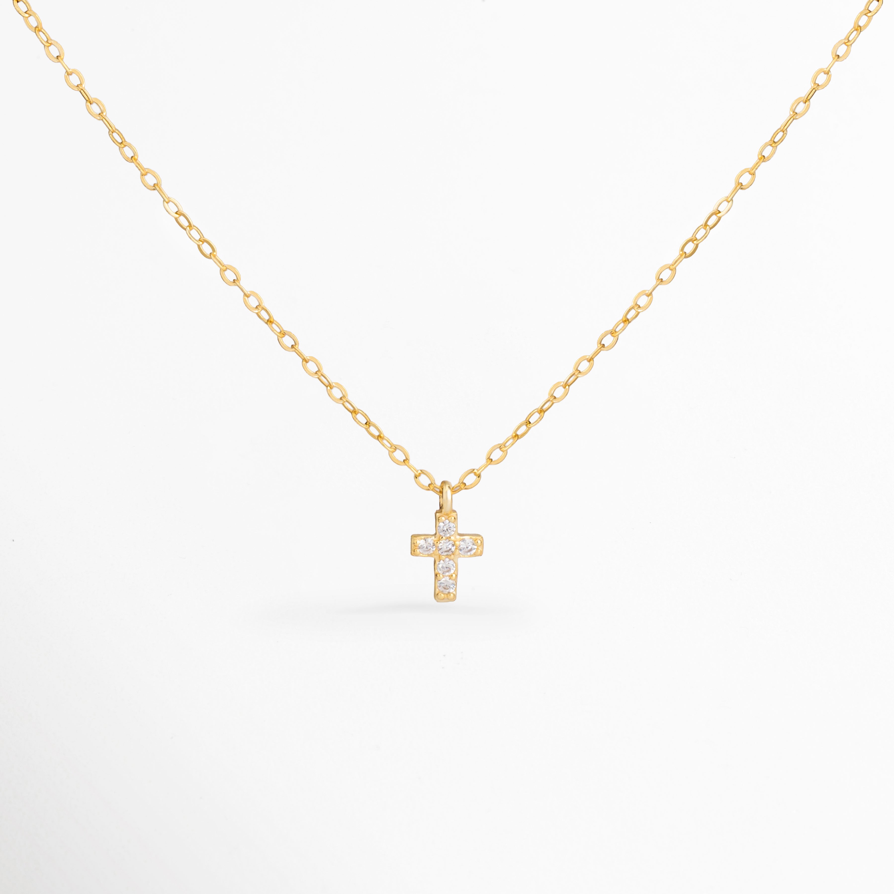 Collar Gloria con cruz mini de zirconias y acabado en oro 14K, Collar dorado con dije de cruz brillante elaborado en plata ley 925, Collar religioso elegante con cruz de zirconias y cadena delicada, Collar Gloria para mujer con diseño minimalista y cruz dorada, Collar con dije de cruz pequeña y zirconias para uso diario.