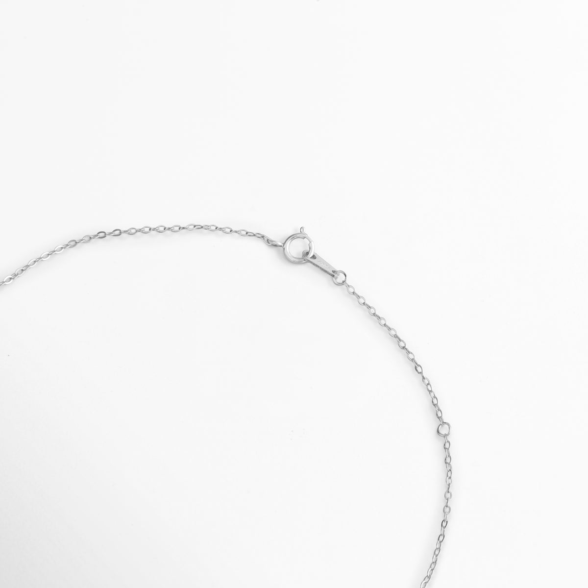 Acercamiento al broche de reasa y la cadena de extensión de 4 cm en la fina cadena de Plata Ley 925 del Collar Silver Gloria, Vista macro del sistema de sujeción y eslabones delicados del collar plateado sobre fondo blanco, Detalle de los eslabones de extensión que permiten adaptar la cadena de 41 cm a 45 cm, Muestra del mecanismo de cierre metálico seguro y pulido en acabado de oro blanco 14K.