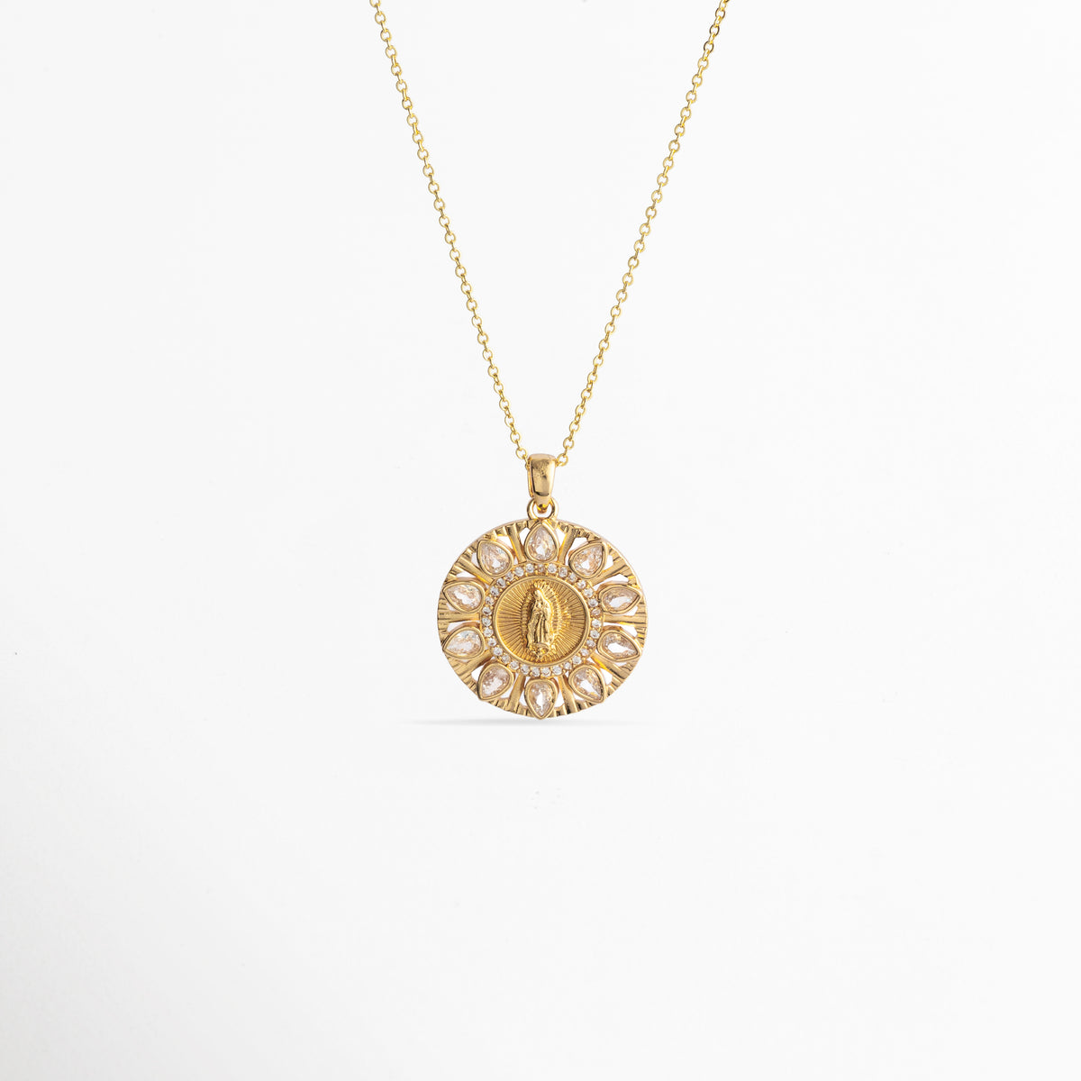 Collar Medalla Virgen Zirconias de cobre enchapado en oro 14K con dije circular de la Virgen rodeado por un resplandor de circonias, vista frontal sobre fondo blanco, vista de frente de collar dorado con medallón místico circular de 3.2 cm de largo con halo calado de pedrería transparente, Plano general de collar fino en tono oro 14K con medalla religiosa circular en relieve sobre fondo neutro, Collar Medalla Virgen Zirconias destacando el contraste entre la figura 