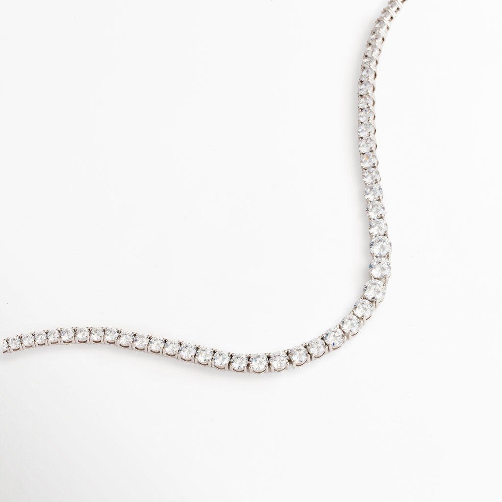 Detalle de zirconias en el Collar Noah, Vista cercana de collar plateado con acabado brillante, Collar con engaste continuo de zirconias, Detalle de cadena elegante con brillo sutil, Acabado refinado del Collar Noah con zirconias.