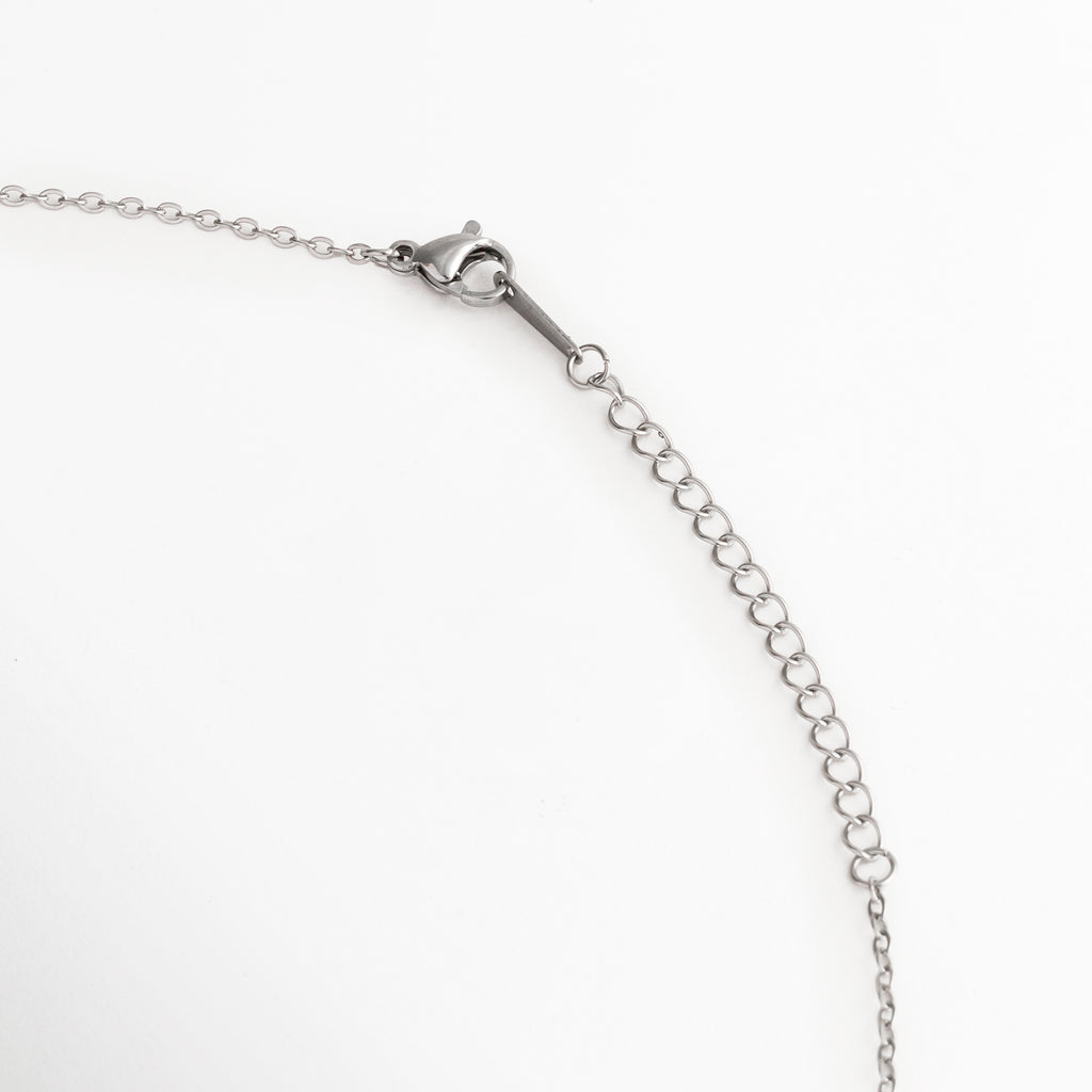 Acercamiento al broche de reasa y la cadena de extensión de 5 cm del Collar Silver Kravitz, Vista macro del sistema de ajuste y cierre seguro en acabado plateado brillante sobre fondo blanco, Detalle de los eslabones de extensión que permiten adaptar la cadena de 40 cm a 45 cm, Muestra del mecanismo de sujeción metálico pulido del collar plateado.