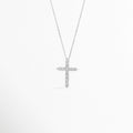 Collar Cruz Eden de plata ley 925 enchapado en oro blanco con dije de cruz latina totalmente cuajado de circonias transparentes, vista de frente sobre fondo blanco, Vista frontal de collar plateado con dije de cruz de 2.5 cm de alto enriquecido con incrustaciones de pedrería brillante, Plano general de collar fino de plata ley 925 enchapado en oro blanco con dije de cruz estilizada sobre cadena de 40 cm, Collar Cruz Eden destacando el resplandor