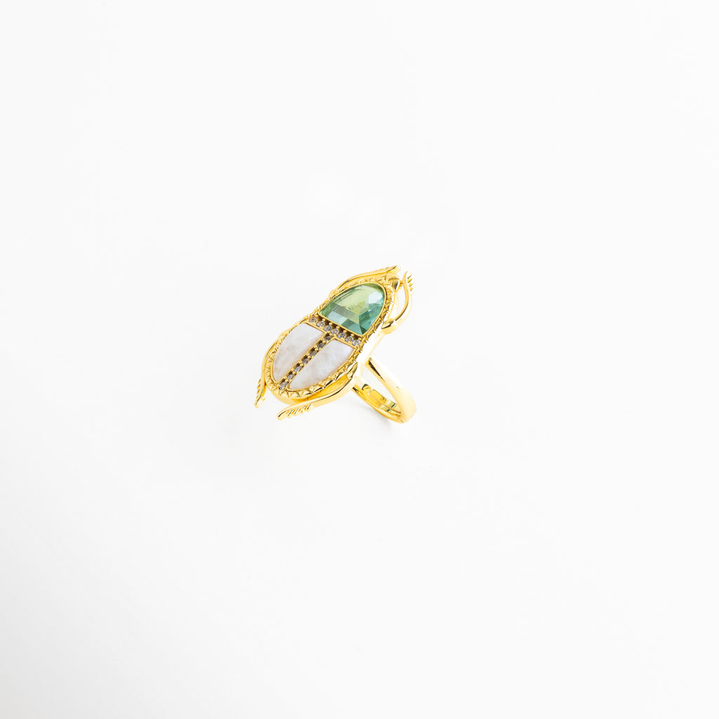 Detalle de cristales de color y zirconias en anillo dorado elegante, Primer plano de piedra central verde con zirconias en anillo ajustable, Acercamiento de cristales brillantes en anillo enchapado en oro 18K, Detalle de incrustaciones en anillo dorado con diseño tipo escarabajo, Cristales y zirconias en anillo elegante con acabado fino dorado