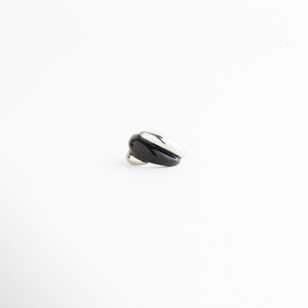 Vista lateral del Anillo Nerisse con diseño curvo y acabado en Oro Blanco, Perfil de anillo moderno con forma orgánica y silueta elegante, Anillo abierto plateado visto de lado con estructura envolvente, Vista de perfil de anillo statement con líneas suaves y contemporáneas, Detalle lateral del Anillo Nerisse con acabado pulido y sofisticado.