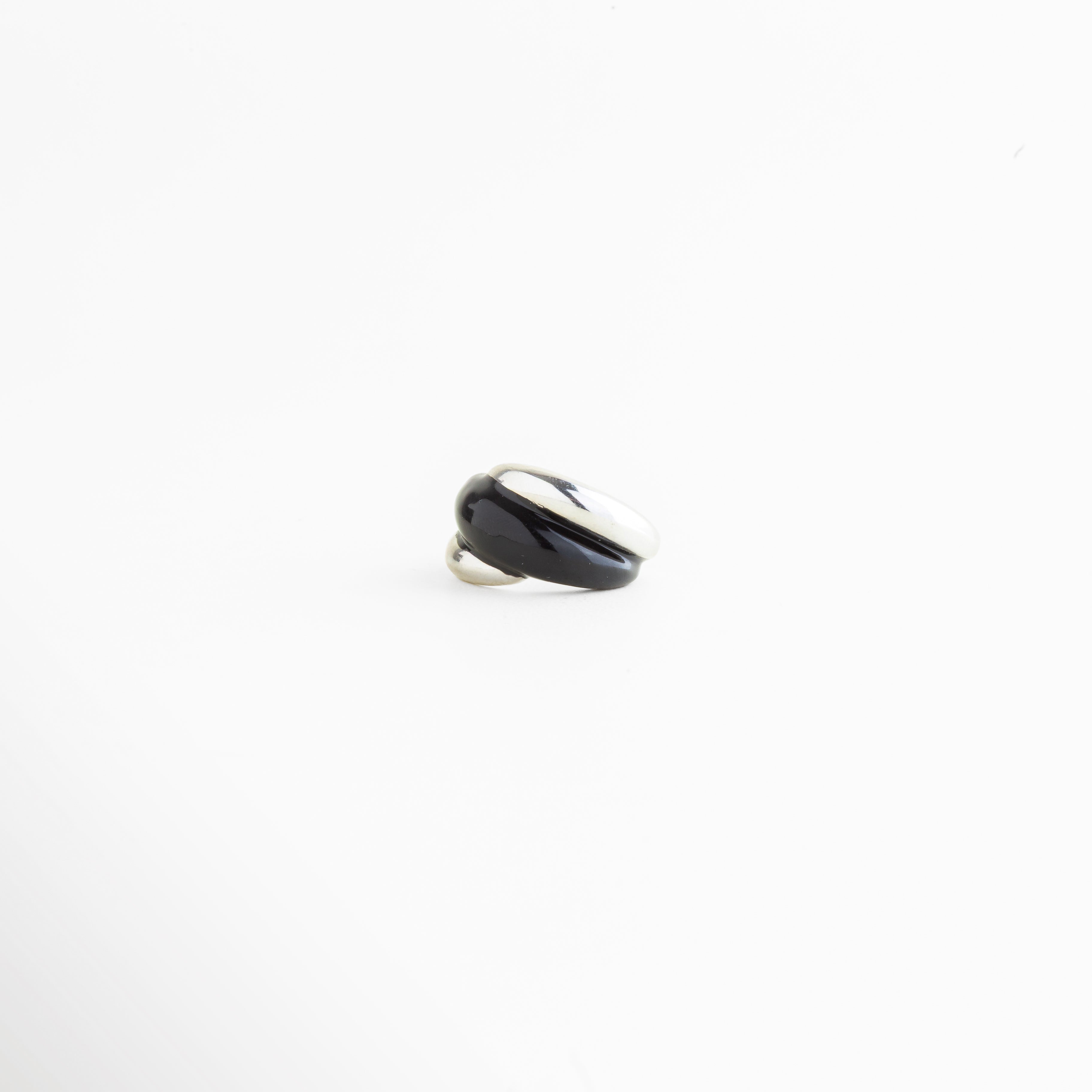 Vista lateral del Anillo Nerisse con diseño curvo y acabado en Oro Blanco, Perfil de anillo moderno con forma orgánica y silueta elegante, Anillo abierto plateado visto de lado con estructura envolvente, Vista de perfil de anillo statement con líneas suaves y contemporáneas, Detalle lateral del Anillo Nerisse con acabado pulido y sofisticado.
