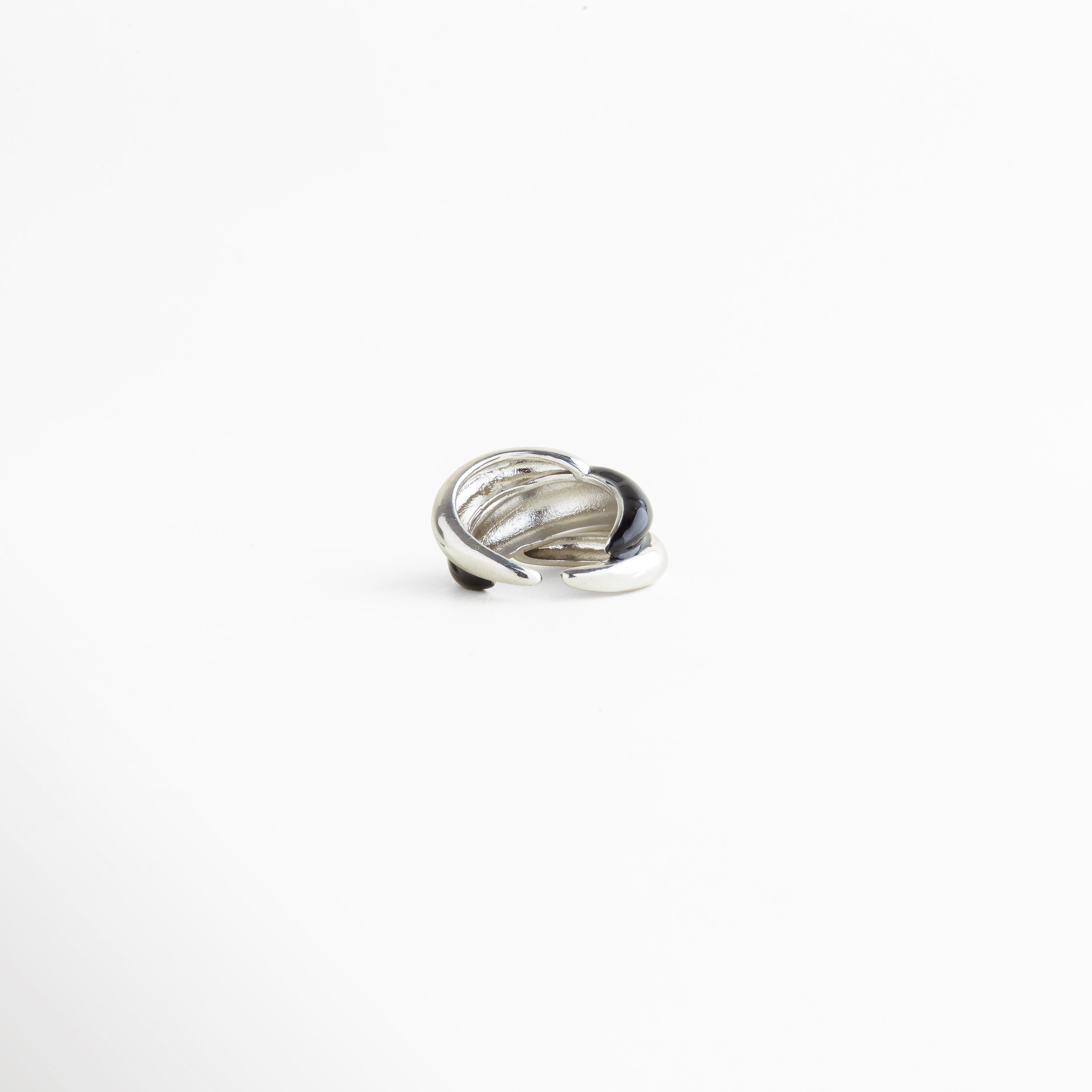 Detalle del Anillo Nerisse con acabado brillante y diseño orgánico refinado, Close up de anillo plateado con forma escultórica y estilo moderno, Detalle del recubrimiento en Oro Blanco del Anillo Nerisse, Acercamiento de anillo femenino con superficie lisa y acabado elegante, Detalle de anillo statement con contraste audaz y textura pulida.